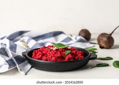 Frying pan with tasty beet risotto on light background
