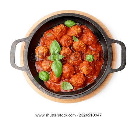 Frying pan of tasty meat balls with tomato sauce and basil on white background