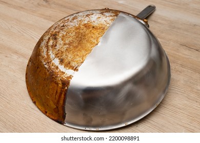 A Frying Pan That Is Half Burnt And Half Polished