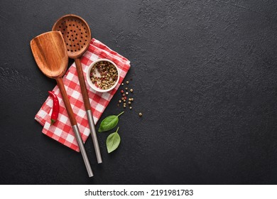 Frying Pan White , Black Empty Plate, Basil Leaves And Spices On Dark Stone Background. Abstract Food Background. Top View Of Dark Rustic Kitchen Table With Wooden Cooking Utensils, Frame. Mock Up.