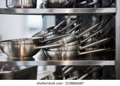 frying pans in a stack on a shelf