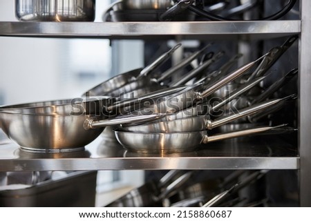 frying pans in a stack on a shelf
