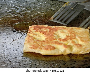 Frying Roti With Cooking Flipper