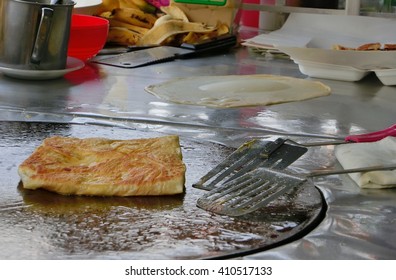 Frying Roti With Cooking Flipper