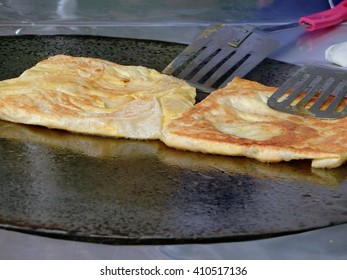 Frying Roti With Cooking Flipper