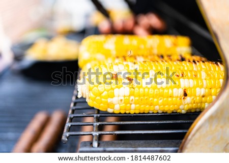 Frying small golden potatoes in cast iron skillet an outdoor gas grill.