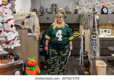 Ft. Lauderdale, Florida, USA - October 29th, 2021 - Green Bay Packers Jersey And Stretch Yoga Pants On A Blonde Fan With Halloween Decorations In Office Cubicle Farm At Work On The Job. 