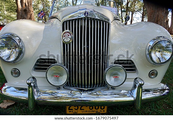 Ft. Myers,\
Florida/USA - March 1, 2020: A horizontal image of the hood, grill,\
and logo on an antique automobile at a car show in southwest\
Florida.                          \
