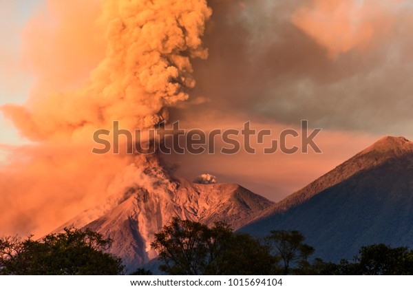 中央アメリカ グアテマラ アンティグアの近く アカテナンゴ火山の近くで夜明けに噴火するフエゴ火山 の写真素材 今すぐ編集