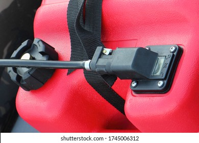 Fuel Connector With Rubber Hose And Filler Cap Of Red Plastic Portable Boat Gas Tank Close Up