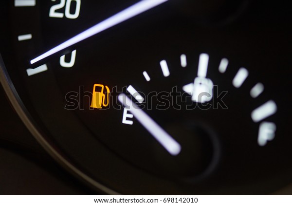 Fuel consumption theme. Empty tank indicator on\
car dashboard