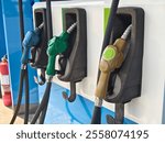 Fuel dispenser nozzles for various types of fuel, arranged at a gas station, designed to cater to different fuel grades and vehicle requirements.