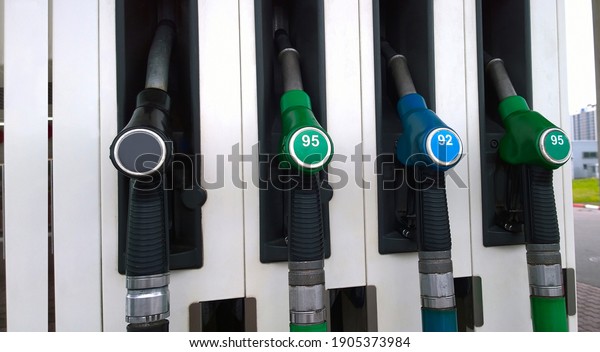 Fuel dispensing pumps green, blue and black\
colour at Petrol station. Gasoline service station. Oil and gas\
price concept. Nozzle\
background.