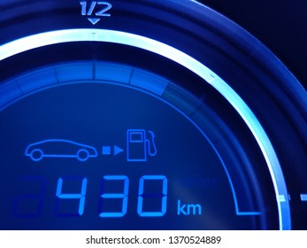 Fuel Economy Gauge With Glowing Digital Technology Indication Of Mileage Remaining To Refueling. Close-up Fragment Of Car Dashboard. Conceptual Photo Of Energy Saving, Climate And Environment Issues.