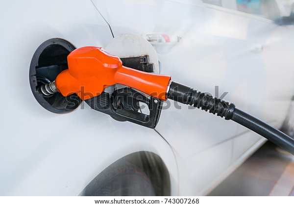 Fuel filler is fill\
in oil in white car.