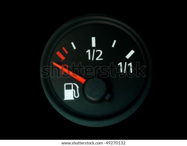 Fuel gauge with a red needle  indicating empty\
on car dashboard isolated on\
black