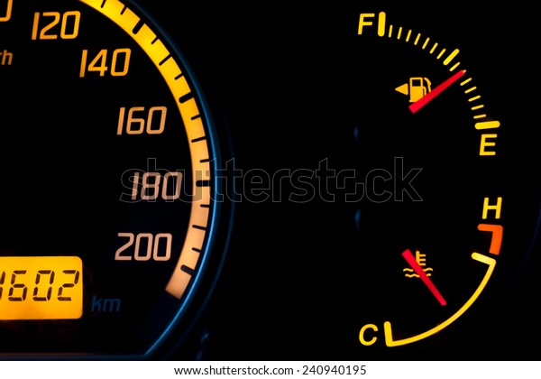 Fuel gauge and\
temperature gauge with a yellow glowing dial. Tank is almost half\
full and the engine is at ideal running temperature. Isolated\
against a black\
background.