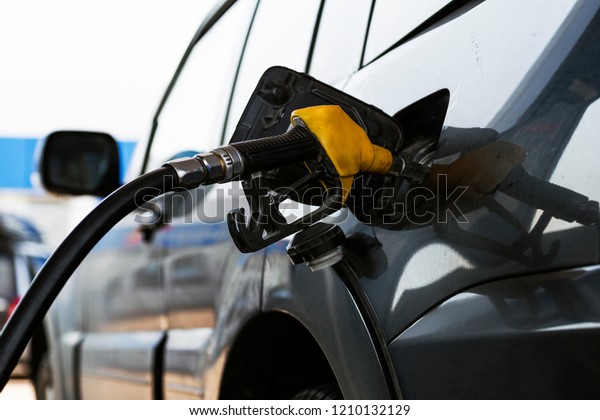 The fuel\
gun is inserted into the tank of the\
car.