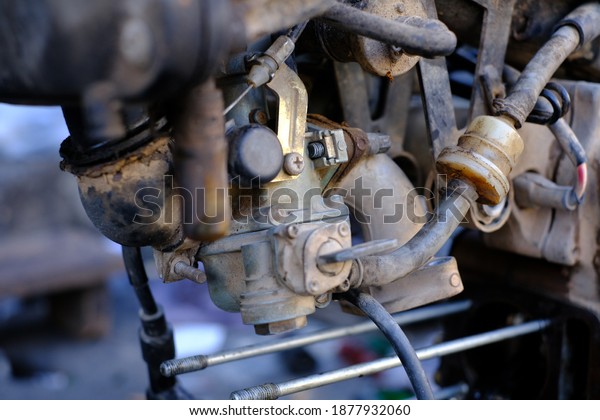 Fuel\
leaking out of the old carburetor. Common carburetor fuel leaks.\
Close-up of dirty carburetor in old motorcycle engine. The problem\
of a carburetor that leaks fuel. Engine\
repair.