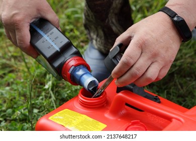 Fuel Mix Preparation With Petroleum And Special 2 T Oil For A Two Stroke Outboard Motor In A Red Boat Fuel Tank Before Use