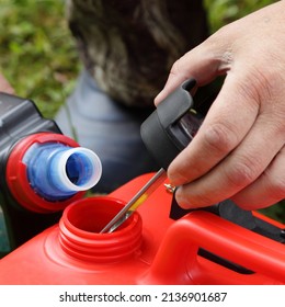 Fuel Mixture Mixing With Gasoline And Blue 2 T Motor Oil For A Two Stroke Outboard Motor In A Red Plastic Boat Gas Tank Close-up