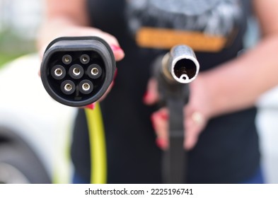 Fuel nozzle and electric car charger plug. EV vs gasoline. - Shutterstock ID 2225196741