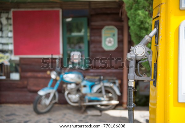 Fuel\
oil dispenser with old motorcycle blurry\
background