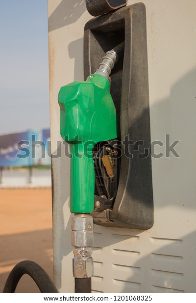 Fuel oil gasoline\
dispenser at petrol filling station.Holding fuel nozzle to refuel\
gasoline for car