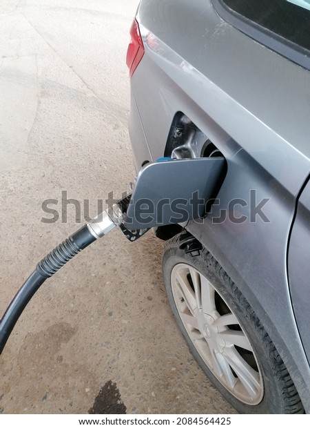 Fuel oil gasoline\
dispenser at petrol filling station.Holding fuel nozzle to refuel\
gasoline for car.