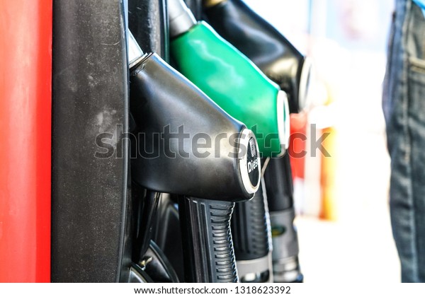 Fuel pistols\
at gas station, focus on diesel\
one.