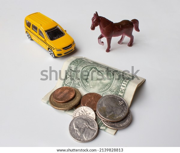 Fuel price rise. World crisis. Savings and high\
fuel prices for cars. Horse, taxi car and American banknotes and\
coins. Conceptual image.