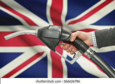 Fuel Pump Nozzle In Hand With Flag On Background - United Kingdom - UK - Great Britain