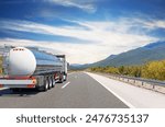 Fuel truck on a picturesque road. A silver tank truck transports fuel.