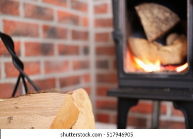 Fuel wood, wood for fireplace, in the background of the wood burning stove, fireplace. Brick old wall background.