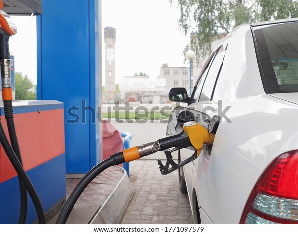 fueling
the car with gasoline. filling gun.  gas
station