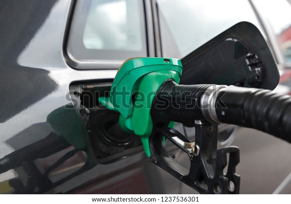 Fueling car with petrol pump at a\
gas station. Petrol station. Gasoline and oil products. Close\
up.