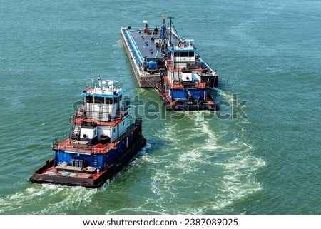 Fueling tugboats and barge pulling away and on to the next vessel.