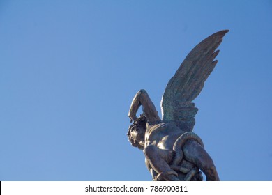 The Fuente Del Ángel Caído (Fountain Of The Fallen Angel) Statue In Retiro Park, Madrid, Spain, Representing The Devil Or Satan Falling From Heaven. With Room For Text.