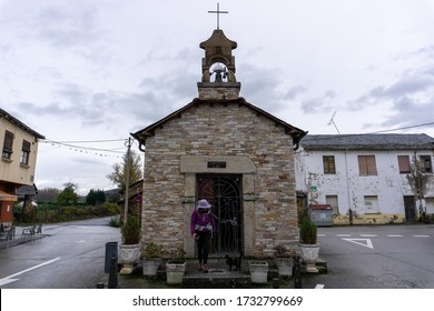 FUENTES NUEVAS, LEÓN, SPAIN - NOVEMBER 11 2019: A Pilgrim And A Cat In Front Of A Small Church On The Way To Santiago De Compostela, St. James Pilgrimage Route