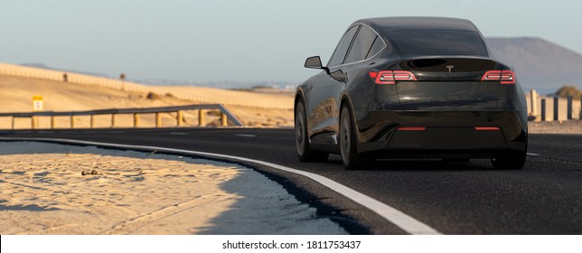 Fuerteventura,Spain-January 2020:Tesla Model Y While Driving Fast Along The Road That Runs Through The Dunes