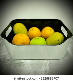Fuit bucket of seasonal fruits consisting of mango, apple, oranges. yellow Fluits rich in vitamin c and beta carotine.Very cheap and available.