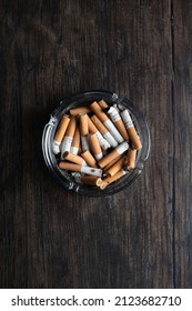 Full Ashtray On Wooden Table