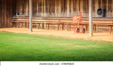 Full Baseball Basket and Dugout: A full baseball basket sitting in an old style wooden dugout.