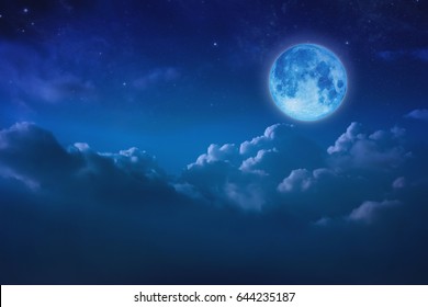 Full blue moon behind cloud over sky and star at night. lunar shine moonlight over cloudy with copy space background for headline text or graphic design. Elements of this image furnished by NASA