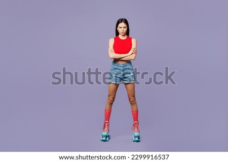 Full body angry sad young latin woman she wear red casual clothes rollers rollerblading hold hands crossed folded look camera isolated on plain pastel purple background. Summer sport leisure concept