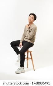 Full Body Asian Man Sitting On High Chair Over White Background