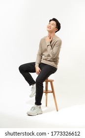 Full Body Asian Man Sitting On High Chair Over White Background