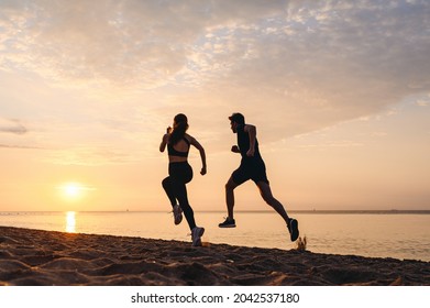 Full Body Back View Couple Young Friends Sporty Sportsman Sportswoman Woman Man In Sport Clothes Warm Up Training Running Jog On Seaside Sunrise Over Sea Sand Ocean Beach Outdoor In Summer Day Morning