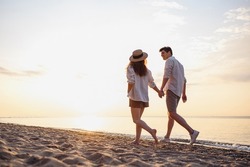 Full Body Back View Young Lovely Couple Two Friends Family Man Woman In Casual Clothes Hold Hands Walking Stroll Together At Sunrise Over Sea Beach Ocean Outdoor Exotic Seaside In Summer Day Evening
