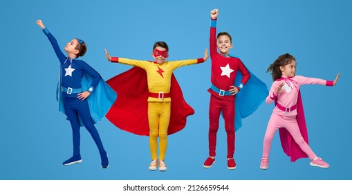 Full body boys and girl in colorful superhero costumes standing in various heroic poses against blue background - Powered by Shutterstock